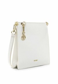 Borsa a mano bianca in pelle con finitura testurizzata, dotata di hardware dorato e una tracolla removibile. Un particolare notevole è il ciondolo circolare.