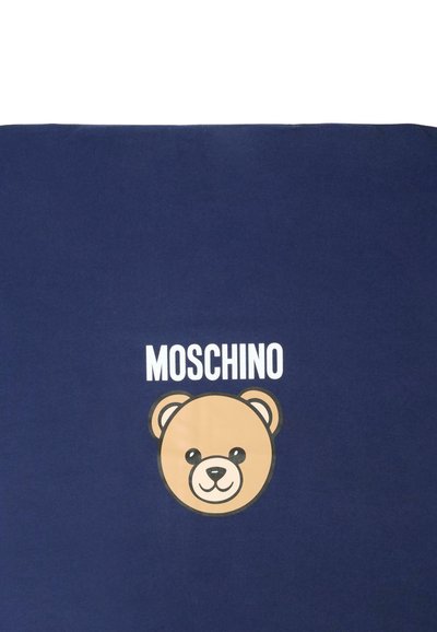 Tissu bleu marine avec un grand visage de ours en cartoon en marron et crème, présentant le nom de la marque "MOSCHINO" au-dessus en lettres blanches en gras.