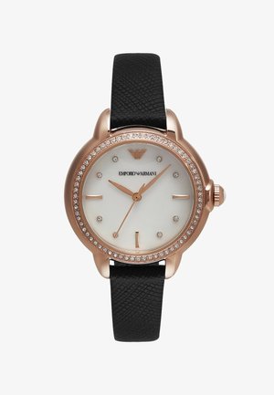 Zlatý hodinky s bílým ciferníkem, černým texturovaným koženým páskem a krystalovými akcenty kolem lunety. Disponuje minimalistickými hodinovými značkami.