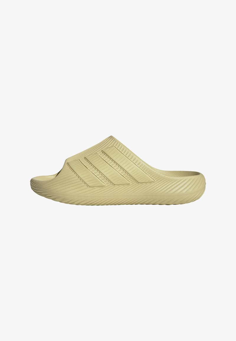 Beige slip-on sandal med tekstureret sål og overdel, der har tre parallelle, forhøjede striber langs siden.