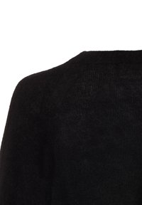 Nahaufnahme einer schwarzen Wollpullover-Schulter und oberen Rücken mit einer weichen, flauschigen Textur vor einem weißen Hintergrund.