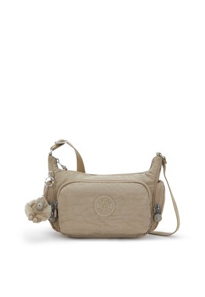 Beżowa torba na ramię z teksturowanym wykończeniem, wyposażona w główną kieszeń na zamek, regulowany pasek oraz dołączony miękki brelok.