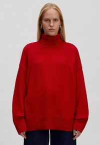 Roter übergroßer Rollkragenpullover mit gerippten Bündchen und Saum, aus weichem Material, mit lockerer Passform und langen Ärmeln.