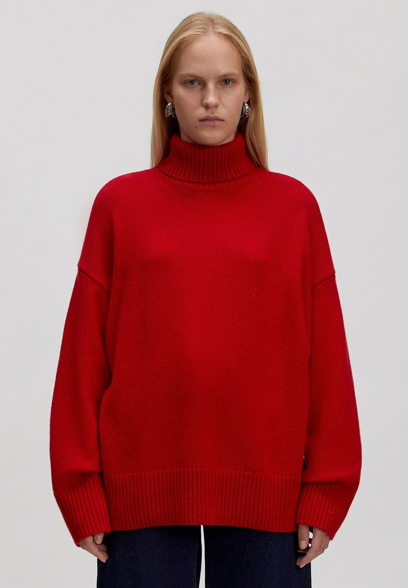 Roter übergroßer Rollkragenpullover mit gerippten Bündchen und Saum, aus weichem Material, mit lockerer Passform und langen Ärmeln.