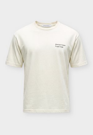 Person set bagfra iført en hvid t-shirt med en sort og rød vinylplade grafik på ryggen.
