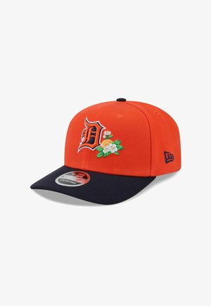 Orangefarbene Baseballkappe mit navyfarbenem Schirm, mit einem stilisierten „D“ und bestickten weißen Blumen mit grünen Blättern.