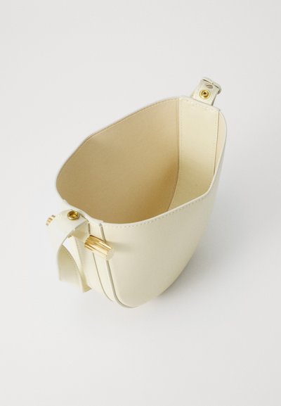 Krēmveida ādas rokassomiņa ar strukturētu formu, gludu tekstūru un zeltaini akcenti slēgšanai un rokturim.