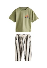 Zöld pamut póló traktor grafikával, krémszínű csíkozott nadrággal, rugalmas derékrésszel és zsebekkel. Egyszerű kialakítás és lazán illeszkedő fazon.