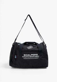 Bolsa de deporte negra hecha de un tejido duradero, con un parche de logo, bolsillo lateral de malla, asas dobles y una correa de hombro ajustable. Texto impreso en blanco.