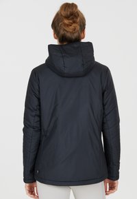Doudoune marine avec capuche, au design épuré, texture matelassée et poignets élastiques. Légère avec une silhouette légèrement ajustée.