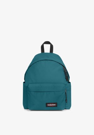 Rucksack aus blaugrünem Stoff mit abgerundetem oberen Teil, vorderer Reißverschlusstasche und schwarzen Schultergurten. Auf der Vorderseite ist ein Logoaufnäher angebracht.