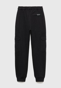 Svarta mjukisbyxor tillverkade av mjukt tyg, med elastisk midja, två sidofickor och ribbade muddar. Enkelt och funktionellt design.