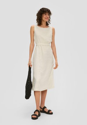 Leinenkleid mit Rundhalsausschnitt, tailliertem Bund und knielangem Saum. Helles Beige, kombiniert mit schwarzen Sandalen und einer strukturierten schwarzen Tasche.