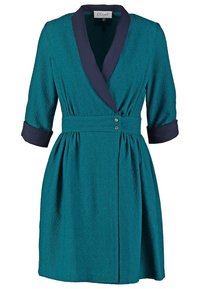 Teal textured wrap dress with navy shawl collar, cuffed three-quarter sleeves, and waist belt with two silver buttons.