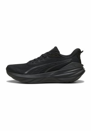 Schwarzer sportlicher Sneaker mit dicker strukturierter Sohle, Schnürdesign und dezenten seitlichen Streifen auf weißem Hintergrund.