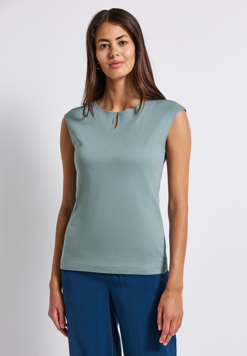 Top de manga corta en color azul verdoso con escote redondeado y un detalle en forma de ojo de cerradura en el collar. Fabricado con una tela texturada y elástica.