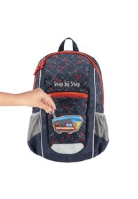 Marineblaue Rucksack mit roten Akzenten, Rautenmuster, vorderer Reißverschluss Tasche mit einem Feuerwehrwagen-Patch, seitlichen Mesh-Taschen und einem Tragegriff.