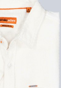 Weißes, strukturiertes kurzärmliges Hemd mit normalem Schnitt. Verfügt über ein oranges Etikett und Knöpfe sowie ein kleines Markenakzent am Saum.