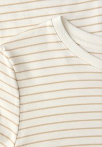 Gestreiftes T-Shirt in Creme mit hellbraunen horizontalen Streifen, aus weichem Baumwollstoff. Mit klassischem Rundhalsausschnitt und kurzen Ärmeln.