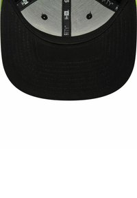 Schwarze Mütze mit flachem Schirm, aus strukturiertem Stoff gefertigt, mit grauem Innenfutter und schwarzen Belüftungslöchern auf der Unterseite des Schirms.