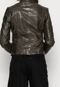 Brązowa skórzana kurtka motocyklowa z teksturowanymi panelami na ramionach i pionowymi przeszyciami. Dopasowany krój o gładkim, błyszczącym wykończeniu.