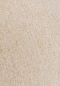 Tissu beige clair avec un motif tacheté doux et subtil et une surface légèrement texturée.