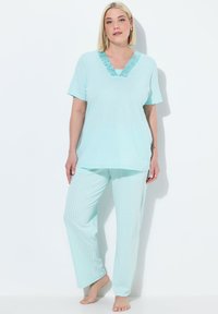 Conjunto de pijama azul claro que incluye una parte superior de manga corta con un escote en forma de V y un acento texturizado, acompañado de pantalones a rayas de corte holgado.