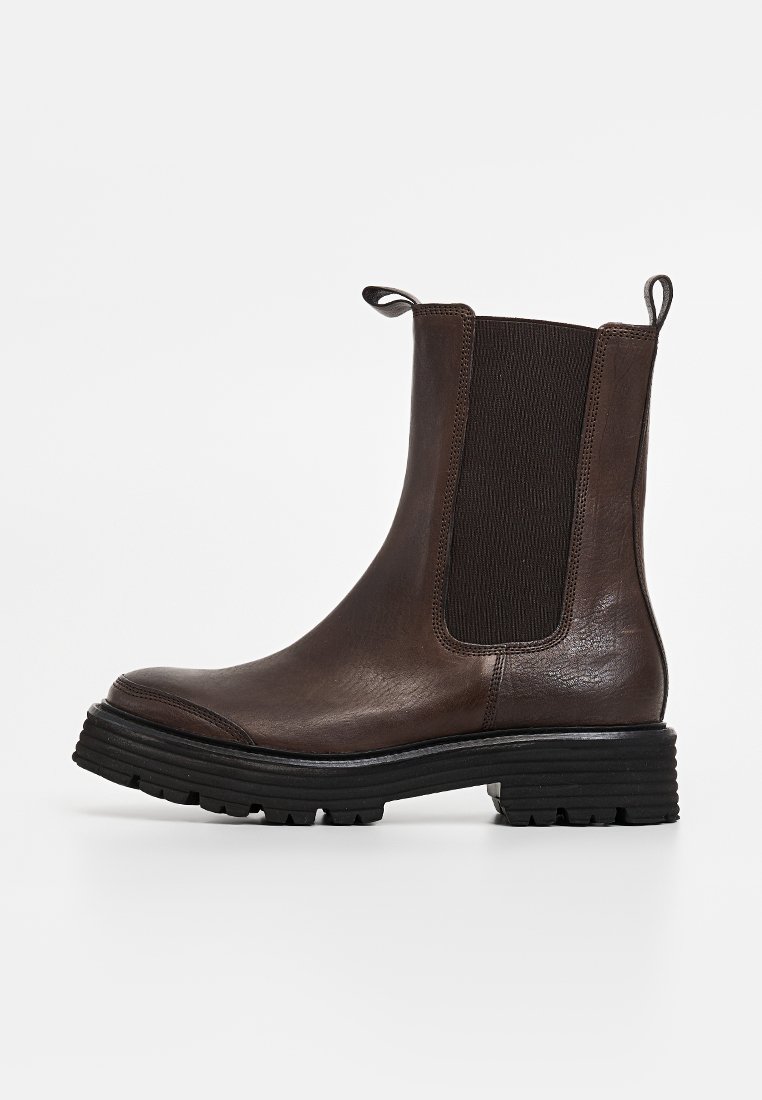 Braune Lederstiefelette mit elastischen Seiteneinsätzen, strukturiertem Obermaterial, runder Zehenpartie und kontrastierender, klobiger schwarzer Gummisohle.