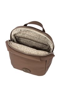 Brązowy skórzany plecak z zamknięciem na zamek, z beżowym wnętrzem ozdobionym powtarzającym się wzorem logo oraz małą kieszonką na zamek wewnątrz.