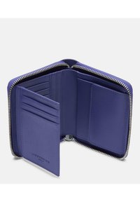 Fioletowy skórzany portfel na zamek otwarty, aby pokazać wiele miejsc na karty i kieszonkę na monety w środku.