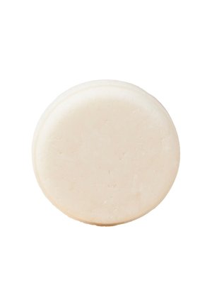 Runde, feste Seife in cremigem, off-weißem Farbton. Glatte Textur ohne sichtbare Muster oder Markierungen. Ca. Durchmesser: 8 cm.