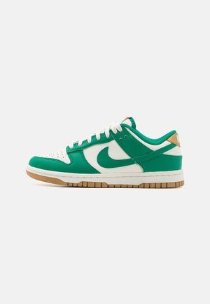 Green and white leather sneakers with a perforated toe, rubber sole, and tan accents on the heel and branding. Laced design.
