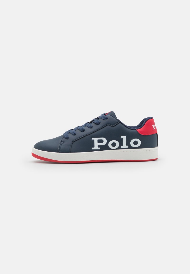 Baskets bleu marine avec texte blanc "Polo" sur le côté, languette rouge au talon, semelle intermédiaire blanche et semelle extérieure rouge, vues de l'extérieur.