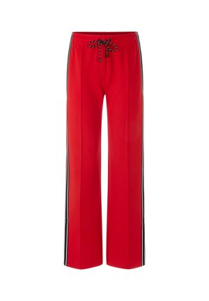 Red sweatpants with a loose fit, featuring black side stripes, an elastic waistband, and adjustable drawstring. Smooth, cotton material.