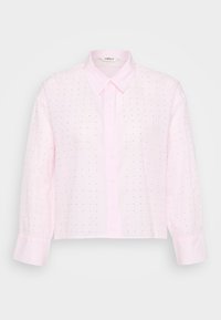 Light pink button-up shirt with a structured collar, long sleeves, and a cropped cut. Features small black polka dots and ribbed texture.