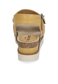 Żółte skórzane sandały z fakturowanym wykończeniem, z korkową wkładką i białą gumową podeszwą. Posiadają regulowany klamrę i otwarty design pięty.