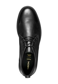 Zapato de cuero negro con un acabado suave, punta redonda y diseño de cordones. Presenta una plantilla suave etiquetada como "GEOX Respira."