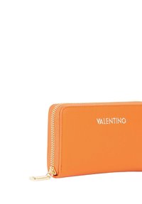 Portafoglio in pelle arancione con una texture liscia, cerniera e accessori dorati, con il logo in rilievo "VALENTINO" sulla parte anteriore.