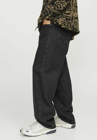 Jeans de pierna ancha negros con un diseño clásico de cinco bolsillos, confeccionados en denim. El exterior presenta un leve desgaste y detalles de costura.