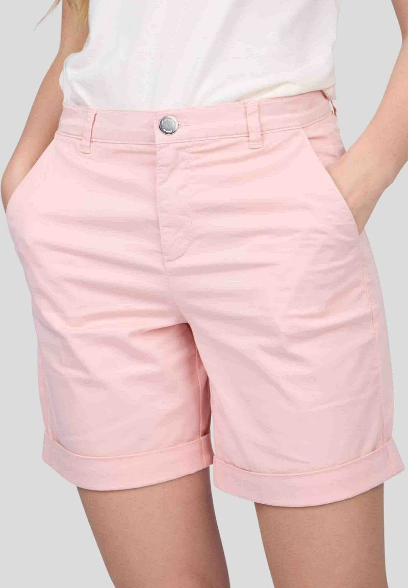 Shorts rose clair en tissu à texture lisse ; dotés d'un ourlet roulé et de poches avant. Fermeture à bouton argenté à la taille.