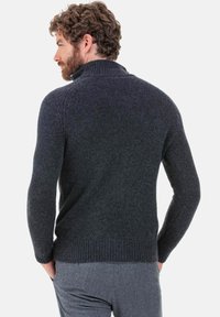Pull en tricot gris foncé avec un col montant. Comprend des poignets et un ourlet côtelés. Conçu avec une coupe ajustée, mettant en valeur un tissu texturé.
