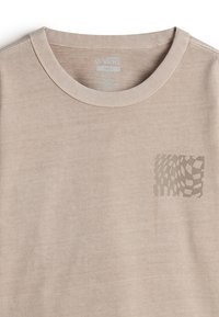 Beige cotton t-shirt with a round neckline. Features a small, abstract checkerboard design on the left chest. Soft texture, casual fit.