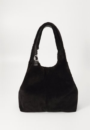 Sac à main en fausse fourrure noire avec une forme arrondie, une courte bandoulière et des accents en métal argenté sur la bandoulière. Texture lisse, design minimaliste.