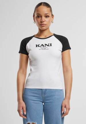 Raglan short-sleeve t-shirt in white and black, featuring bold black print "KANI" at the center. Soft cotton material, fitted style.