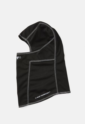 Capuche noire en tissu texturé, ornée de coutures argentées contrastées, au design angulaire, avec une étiquette indiquant "T1-KCUF TECHNOLOGY™."