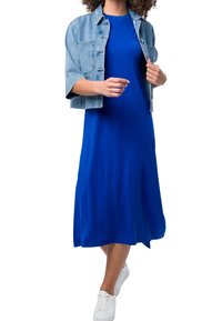 Sininen jerseyn dressi, jossa on rento malli, yhdistettynä lyhytnaamioiseen vaalean denim jacketiin, jossa on lyhyet hihat ja etupainikkeet, käytettynä valkoisten tennareiden kanssa.