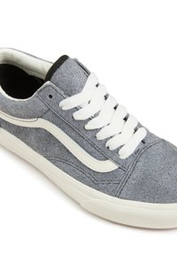 Adidași din suede gri cu șireturi albe și o dungă laterală albă contrastantă; au o talpă din cauciuc și o căptușeală interioară netedă.