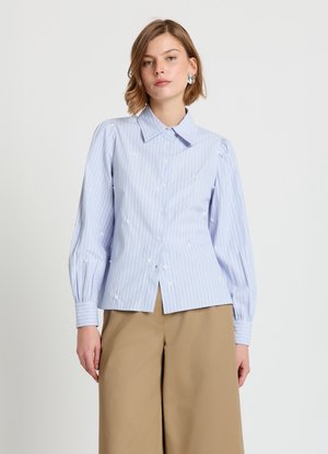 Hellblau gestreiftes Hemd mit Puffärmeln und bestickten Blumenakzenten. Baumwollstoff mit glatter Textur. Mit Kragen versehen.