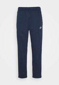 Tmavě modré tepláky vyrobené z bavlněné směsi, s elastickým pasem na šňůrku a malým bílým logem Nike na levé straně.