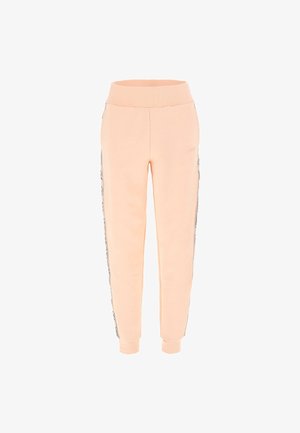 Peachfarvede sweatpants med elastisk talje, manchetter ved anklerne og sorte sidestriber med mønstrede detaljer. Blødt og strækbart materiale.
